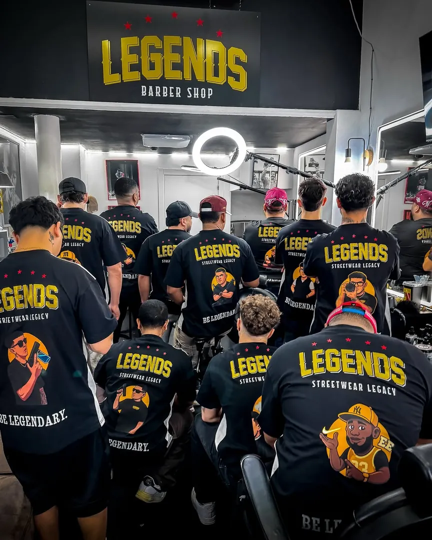 Equipo de Legends Barbershop de espaldas con sus camisetas negras personalizadas con el logo Legends y una ilustración.